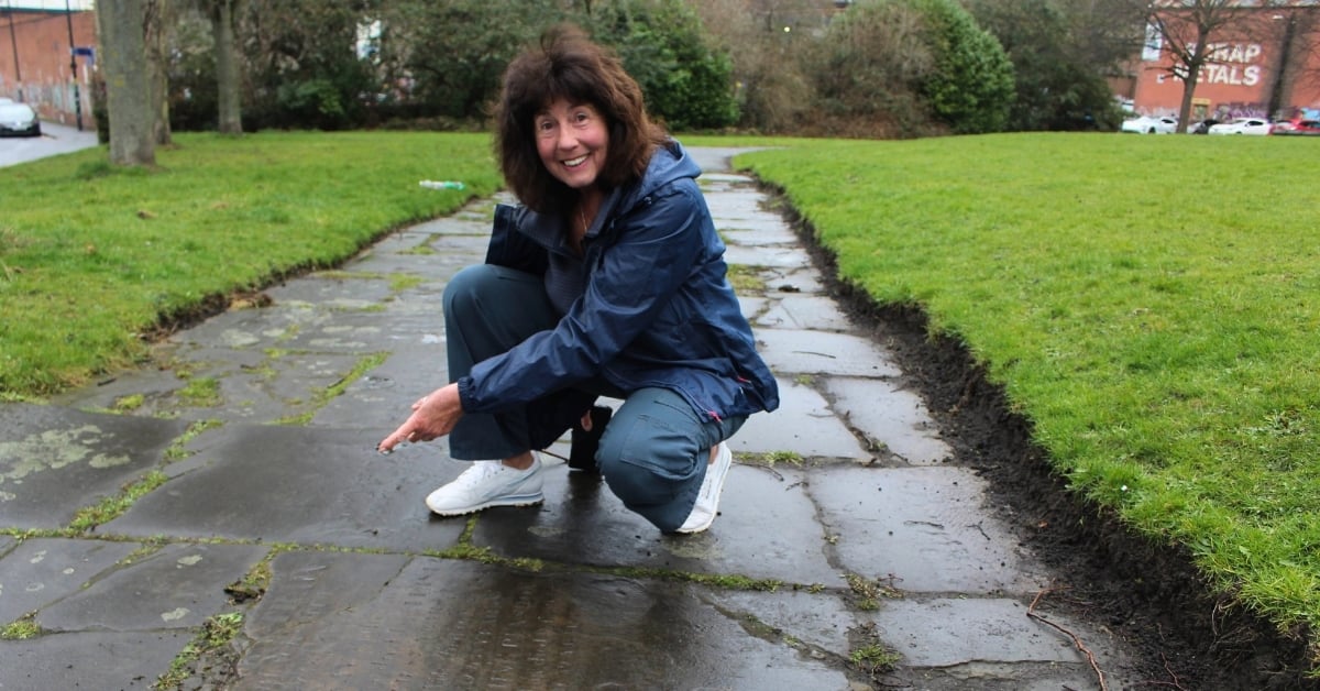 Person pointing at gravestone