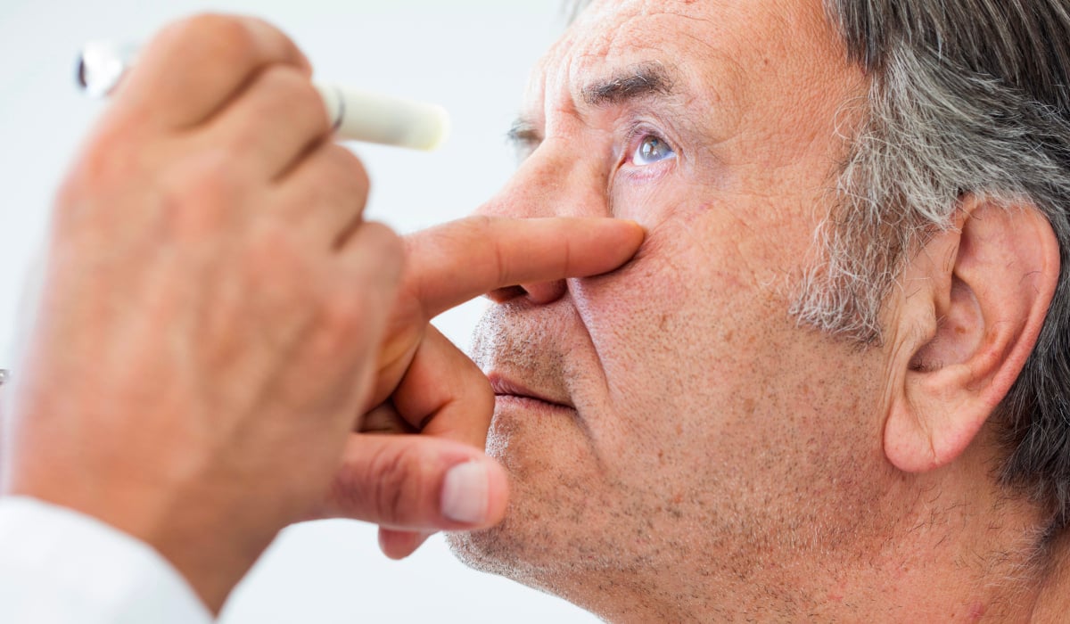 An ophthalmologist examines a patient's eye.