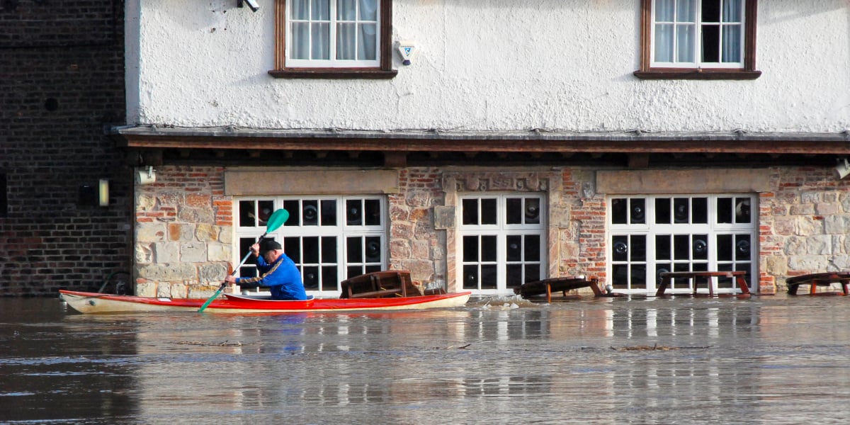 Man paddles past a flooded building along the River Ouse, York.