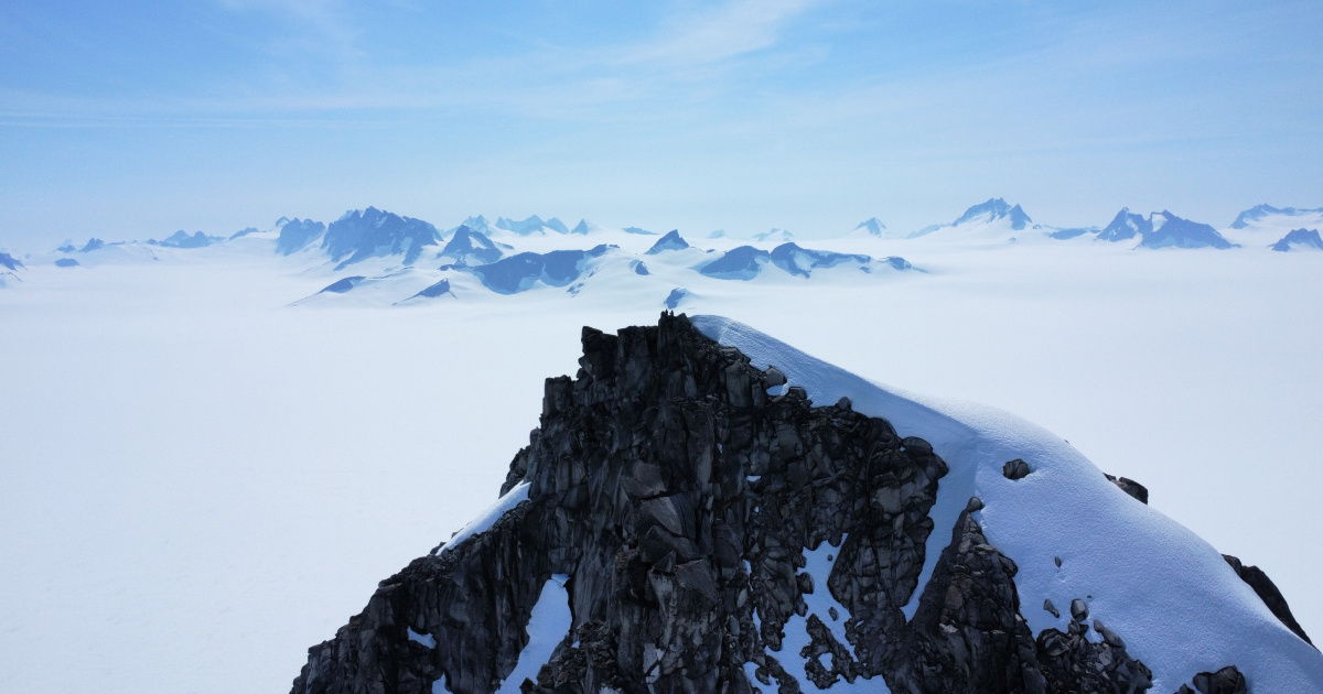 The peak of a mountain overlooking the snow-covered plateau of Taku Glacier