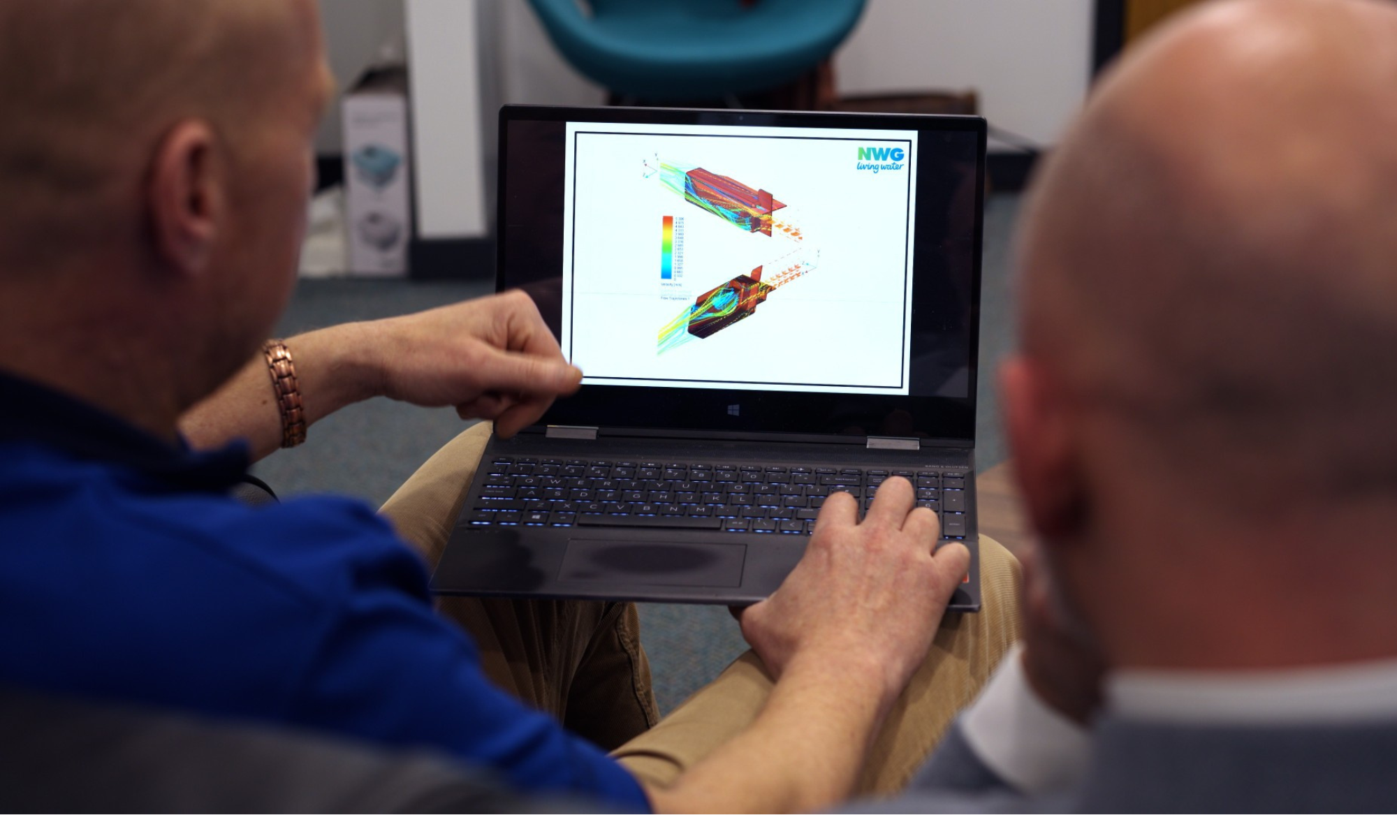 Two men looking at a scientific design on a laptop