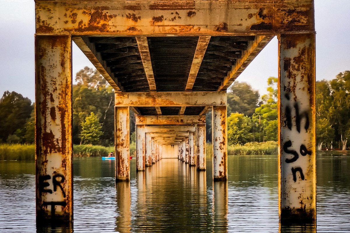 Rusty bridge pillars submerged in water