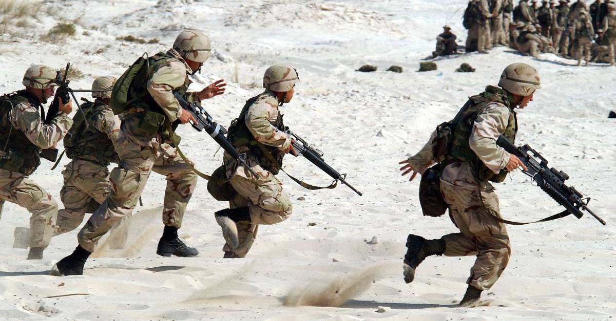 Soldiers_running_with_guns_on_sandy_terrain