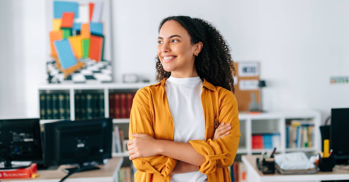 a female entrepreneur smiles while standing in an office