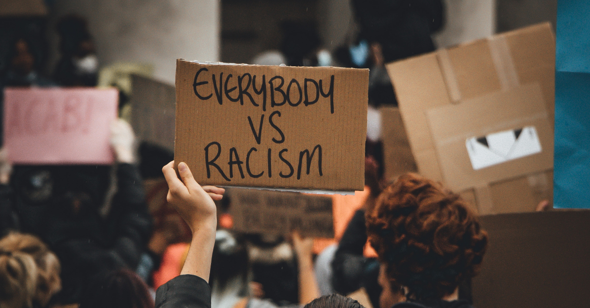 protest against racism person holds sign that says everybody vs racism